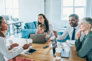 Shot of a multi-ethnic group of business people having a meeting in a modern office. Young working mother and her cute little daughter on business meeting in the office.