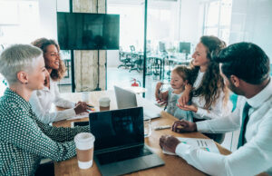 Shot of a multi-ethnic group of business people having a meeting in a modern office. Young working mother and her cute little daughter on business meeting in the office.